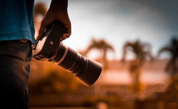 midsection-man-holding-digital-camera-while-standing-outdoors 1